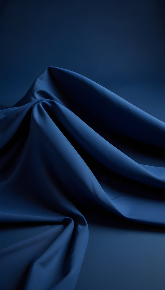 Elegant draped blue fabric showcasing texture and depth against a soft dark background during soft lighting in a studio setting