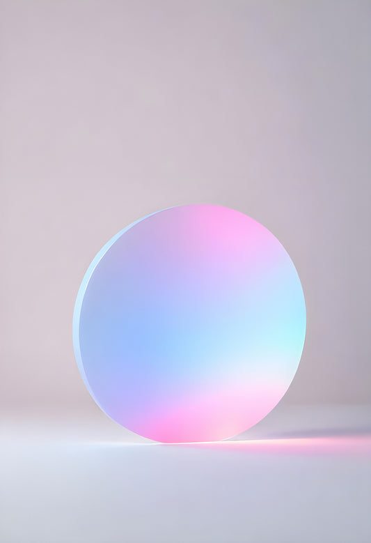 Glowing circular object casting soft pastel colors against a minimalist backdrop in a softly lit studio environment