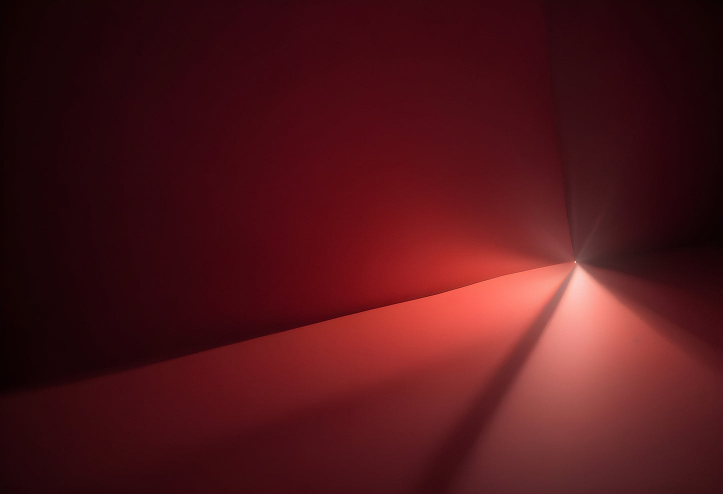 Mysterious red gradient light illuminating an abstract space with dramatic angles at dusk