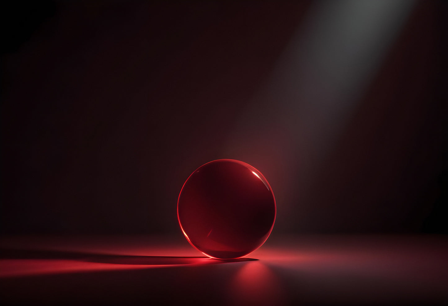 A solitary red sphere illuminated by soft light in a dark space