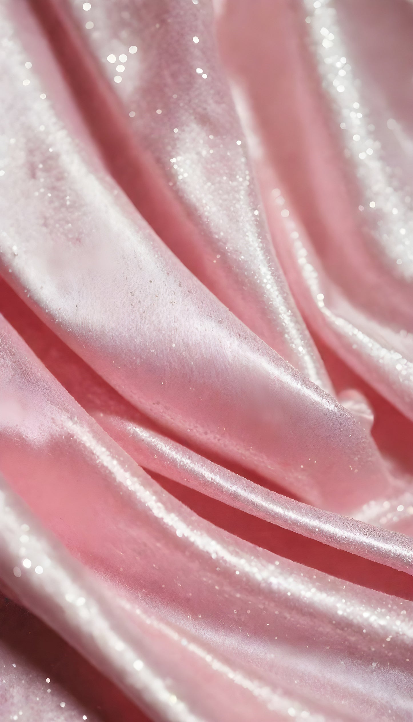 A close-up view of soft, shiny pink fabric draped elegantly, highlighting its smooth texture and sheen, perfect for luxurious designs