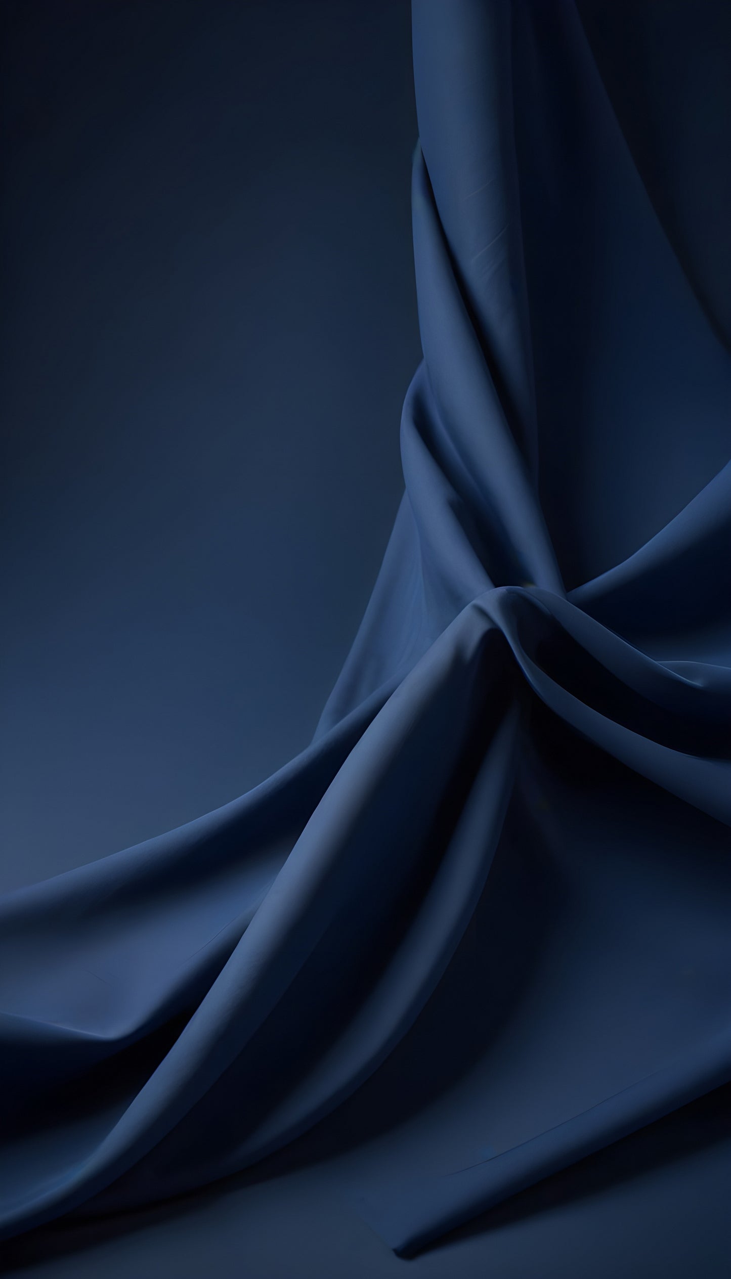 Deep blue fabric draped elegantly, showcasing intricate folds and a smooth texture against a dark background