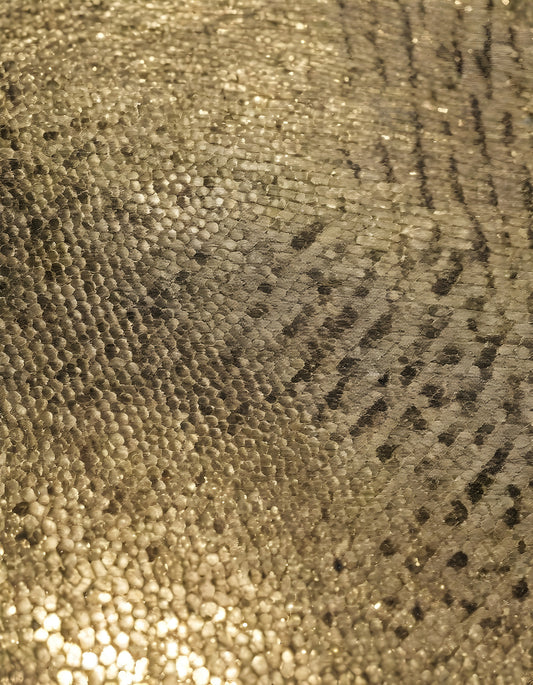 Sparkling golden fabric draping gracefully under soft light during a creative textile project