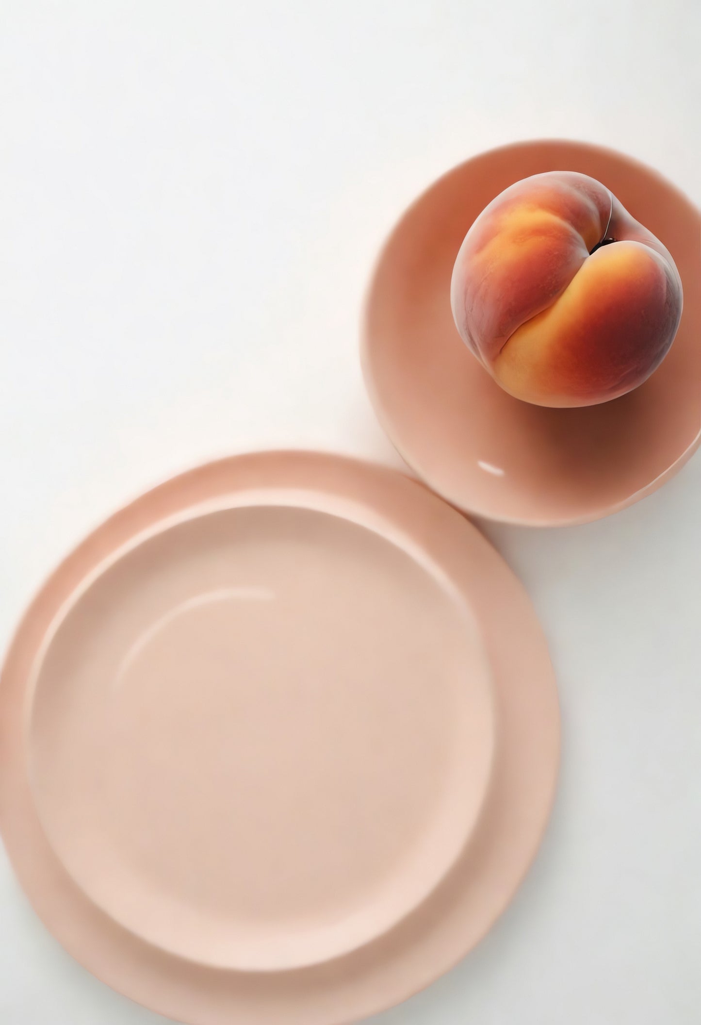 Simple peach resting on a pale plate, showcasing minimalistic styling and soft colors in a serene setting