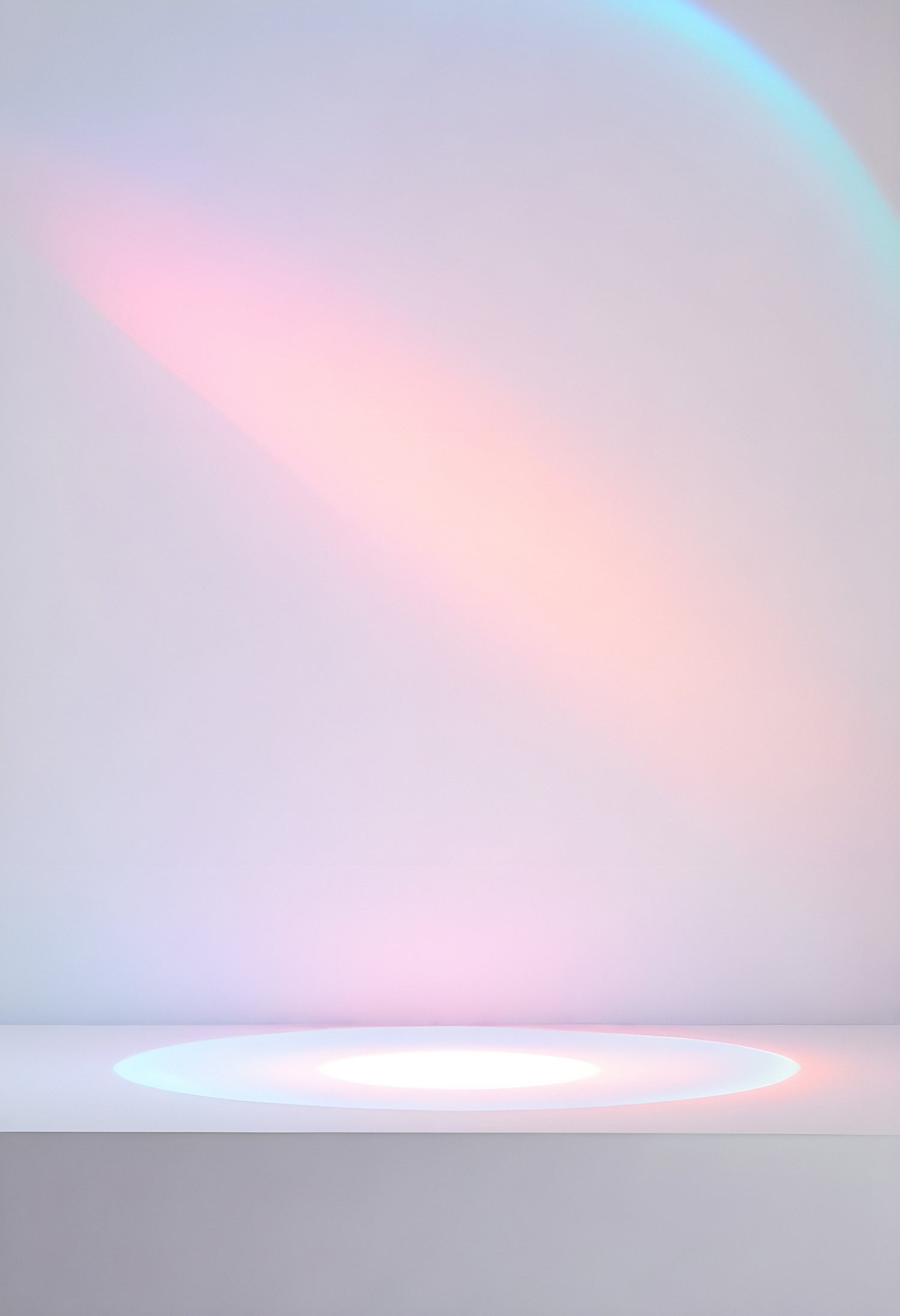 Soft pastel light reflecting off a simple white surface with a subtle rainbow effect in a calm, minimal indoor setting