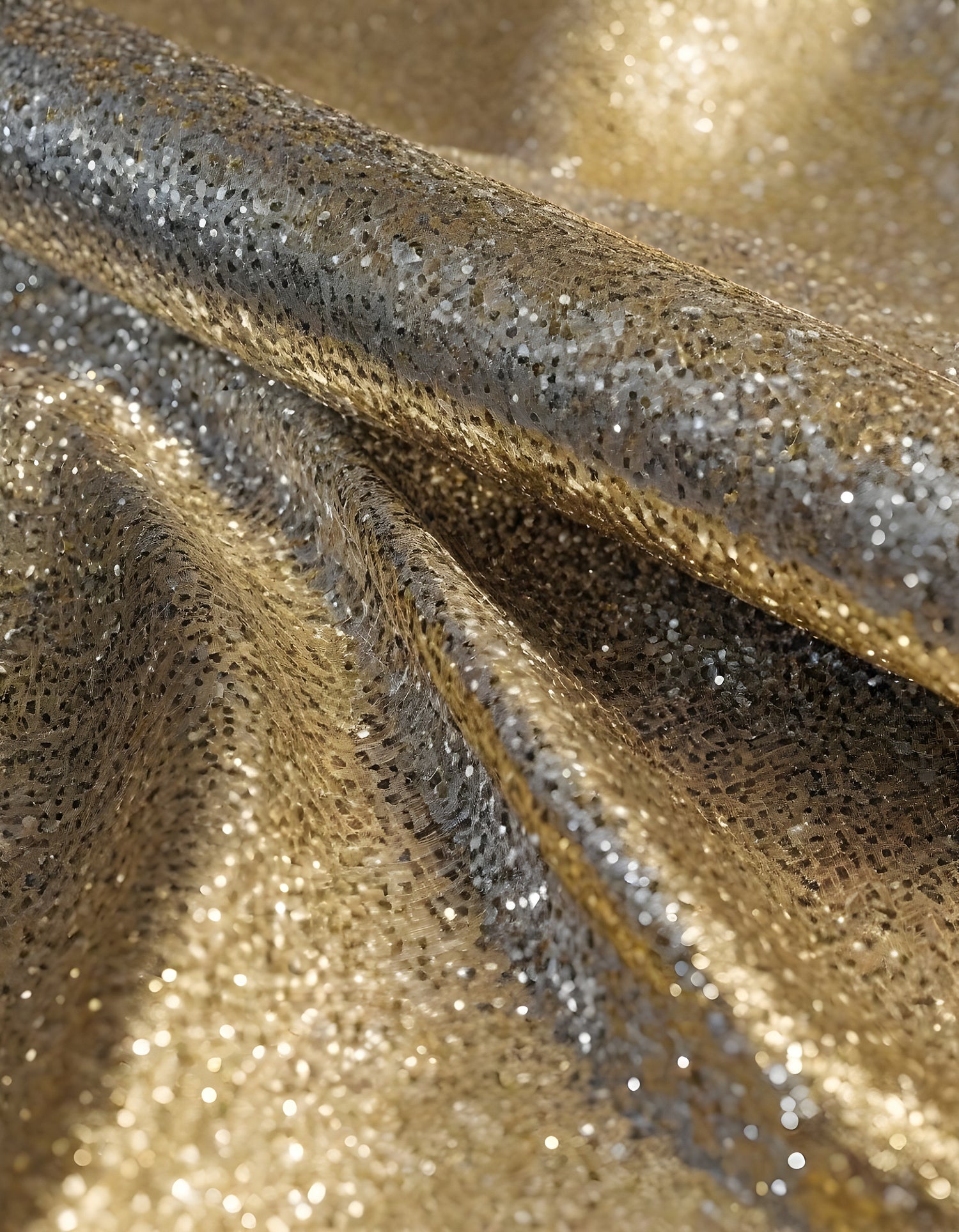 Metallic golden and silver fabric creates elegant textures with intricate folds and reflections under soft lighting