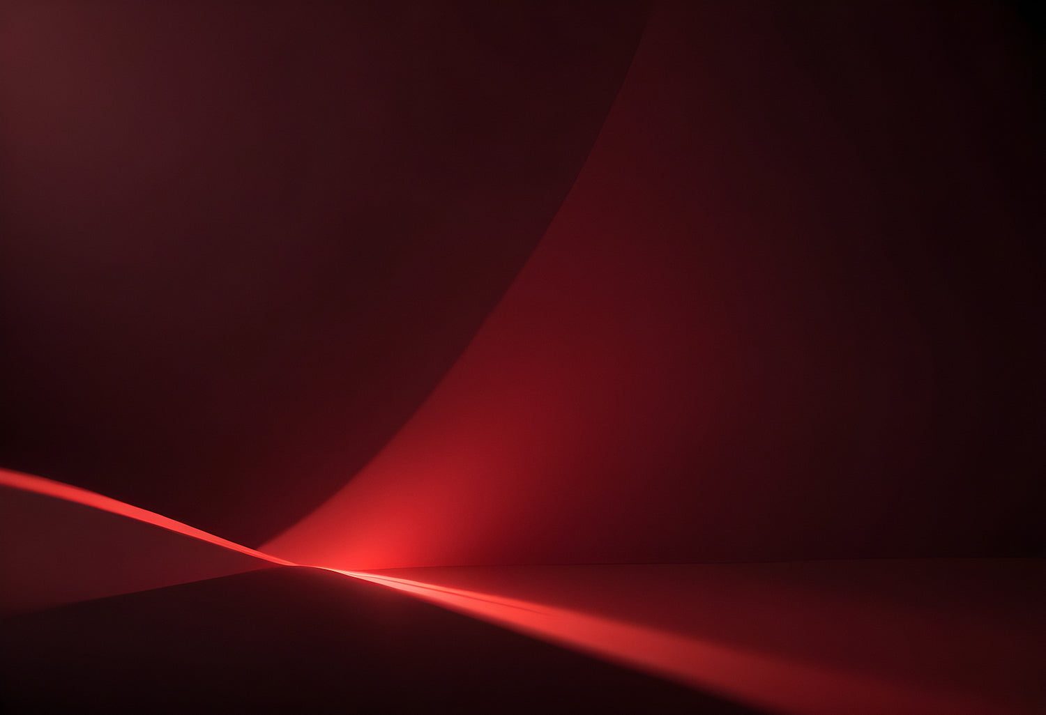 A soft glowing curve against a deep red background creates an abstract and calming visual experience in a minimalist setting