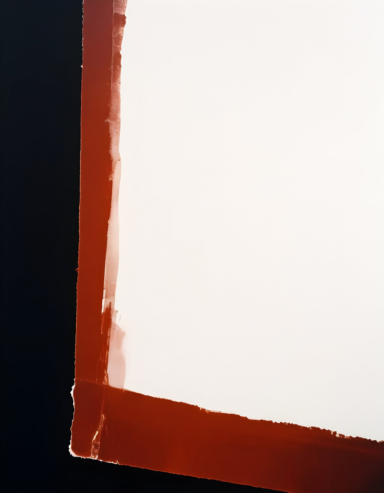 A blank canvas with a dark background and red tape border in an artist's studio