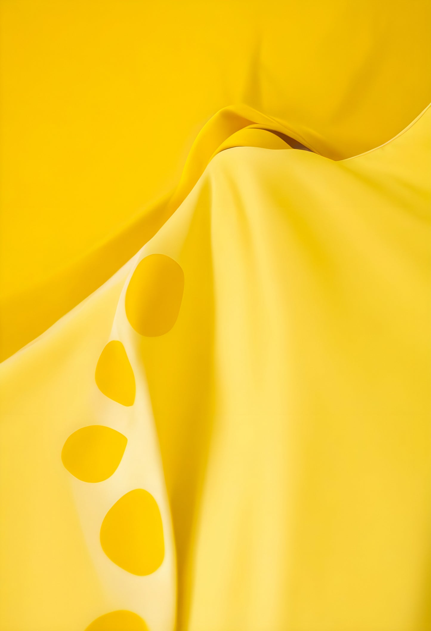 Bright yellow fabric draped with a playful design showcasing vibrant circles in a soft, flowing arrangement