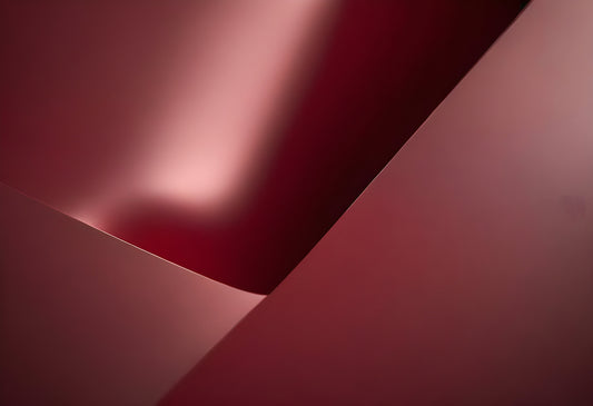 Abstract close-up of red metallic surface creating smooth curves and shadows, highlighting texture and light interaction in contemporary design