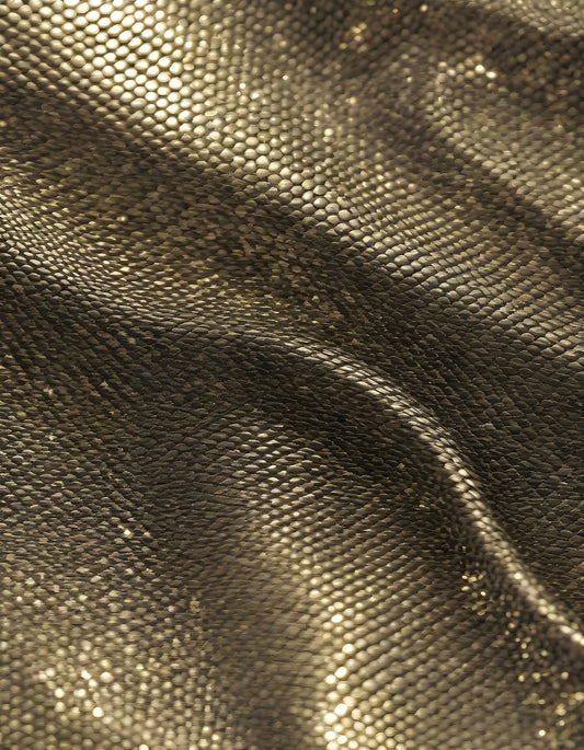 Sparkling golden fabric draping gracefully under soft light during a creative textile project