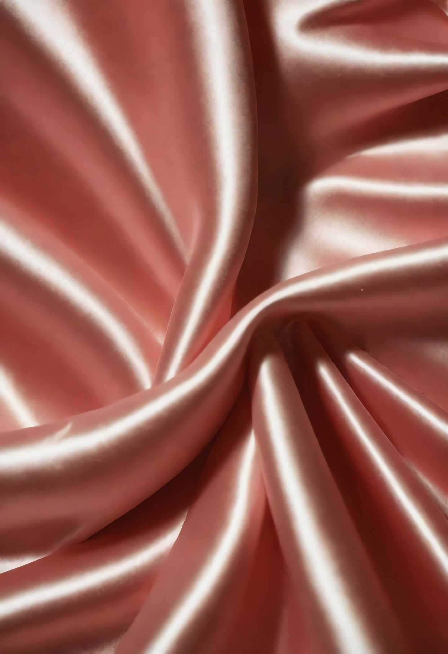 Soft pink satin fabric draping on a surface, showcasing smooth texture and elegant folds