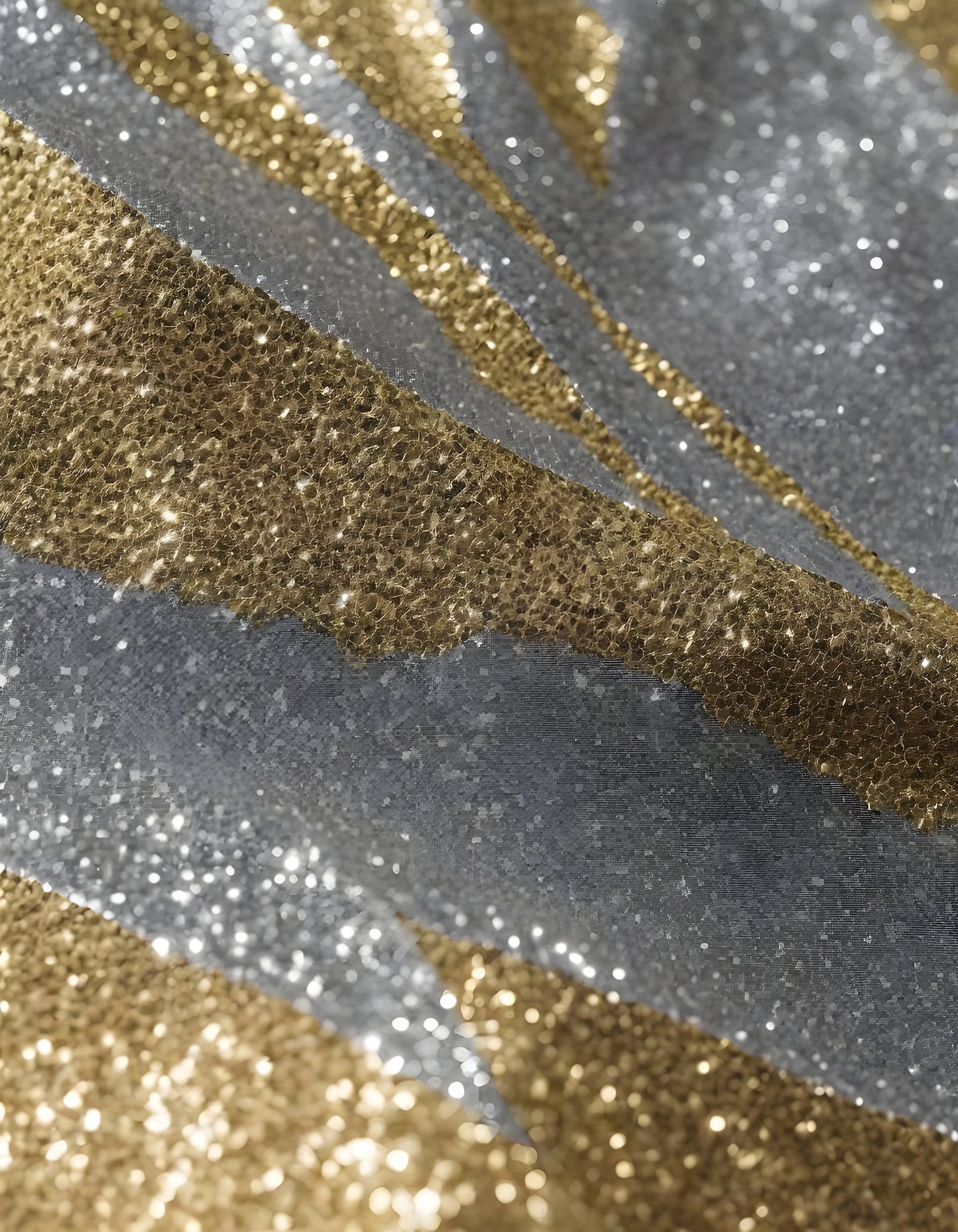 Shimmering gold and silver glitter fabric draped elegantly under soft lighting in a creative workspace