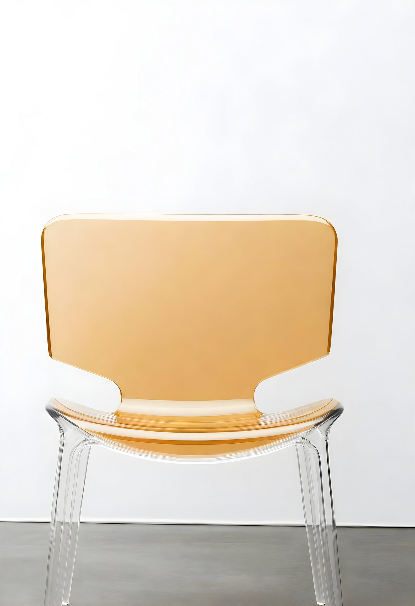 Transparent modern chair displayed against a minimalist white wall in a contemporary interior setting during daylight