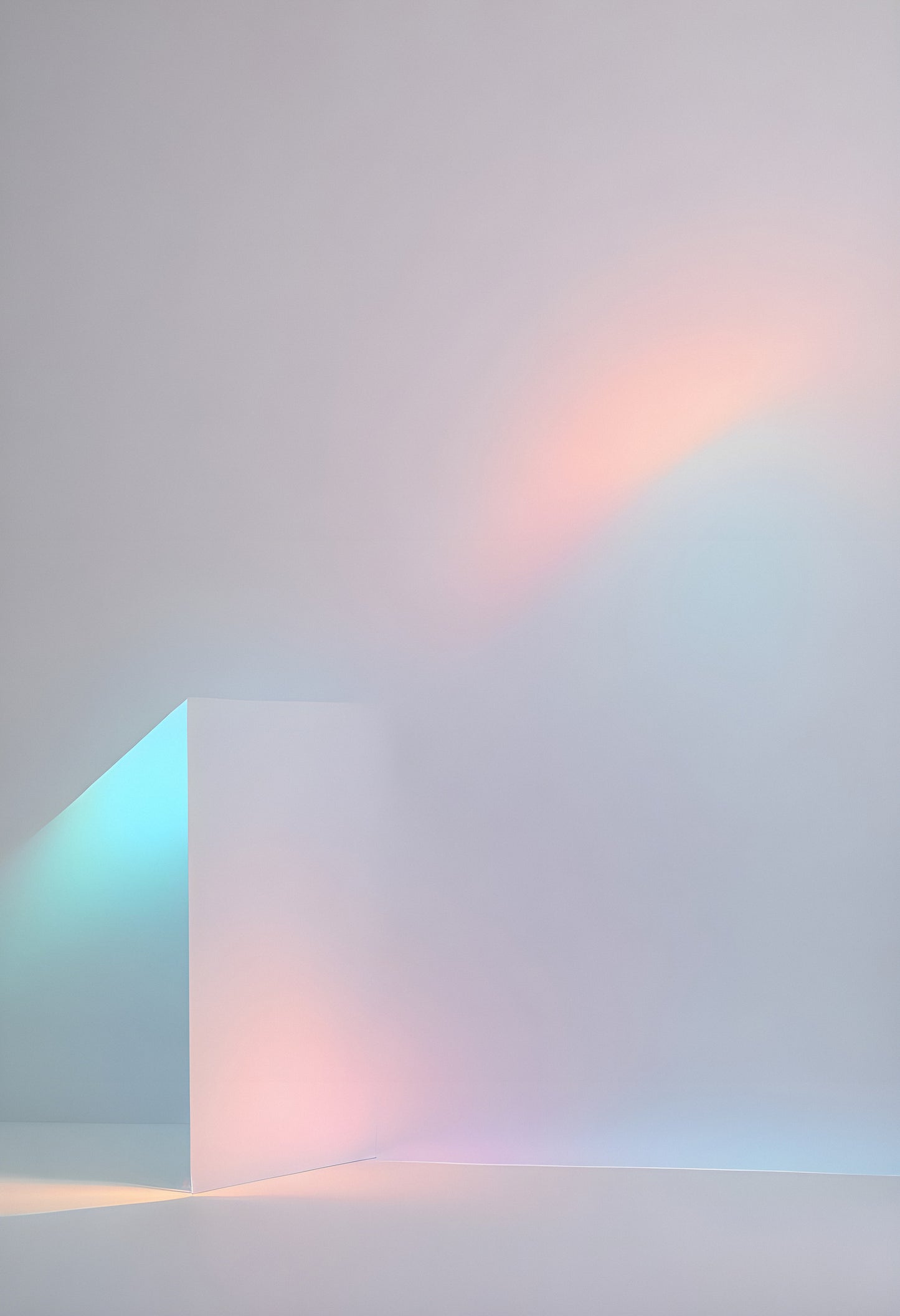 Abstract arrangement of translucent shapes casting soft pastel colors onto a light background indoors