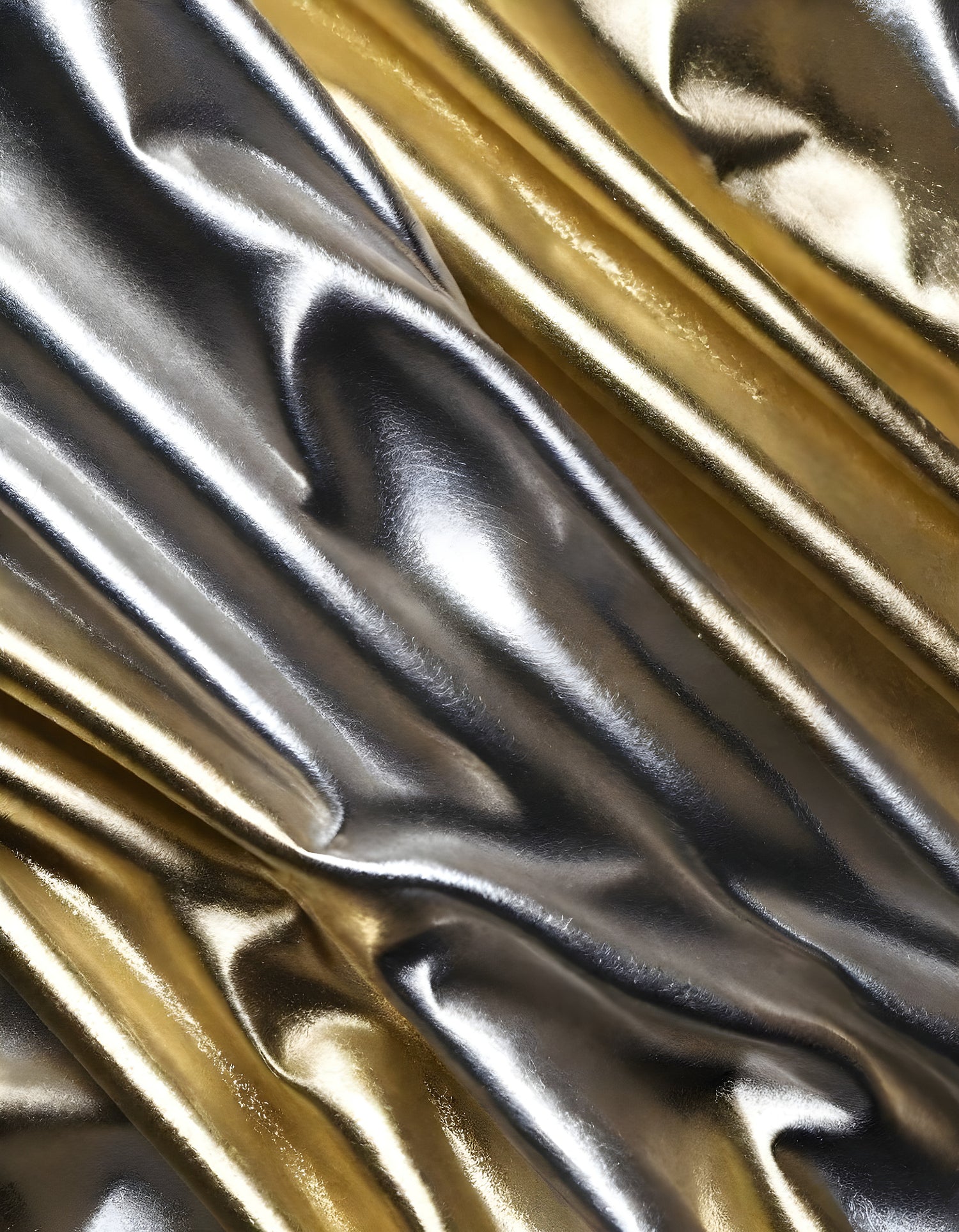 Shimmering gold and silver fabrics layered together in a luxurious arrangement during daylight