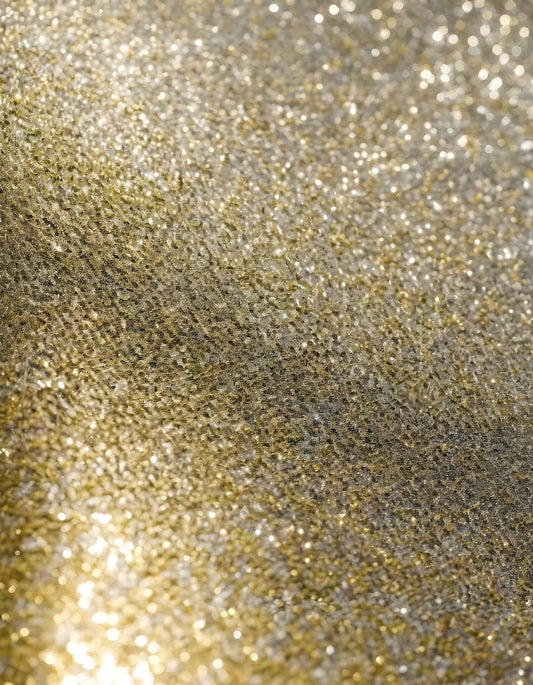 Shimmering gold texture close-up with glimmering sparkles under soft light