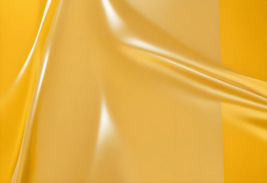 Bright yellow silk fabric with gentle folds creating a dynamic texture and depth in natural lighting during the day