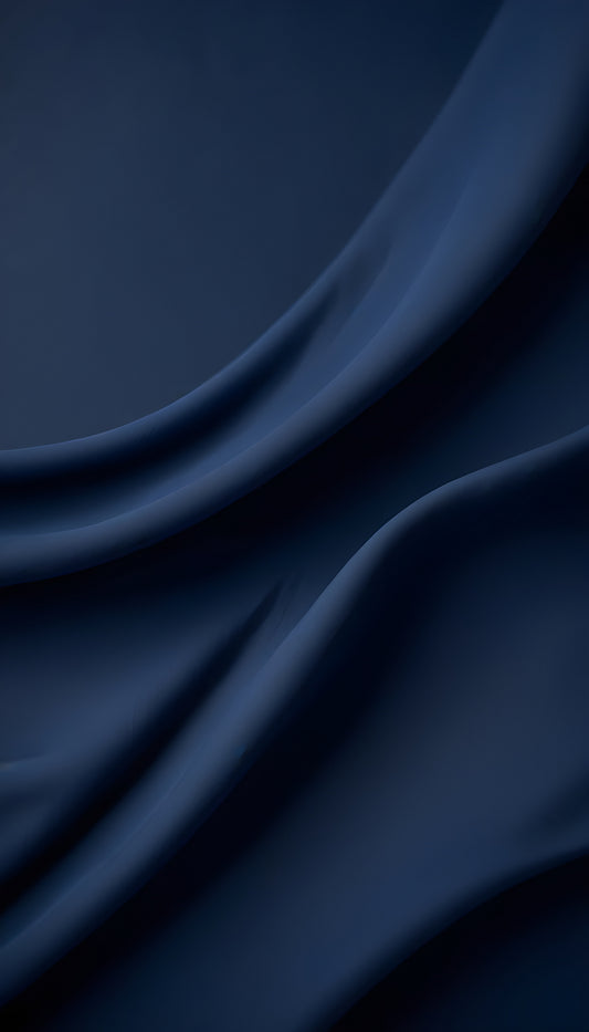 Rich navy blue fabric drapes elegantly across a surface, showcasing its soft texture and subtle sheen in warm light