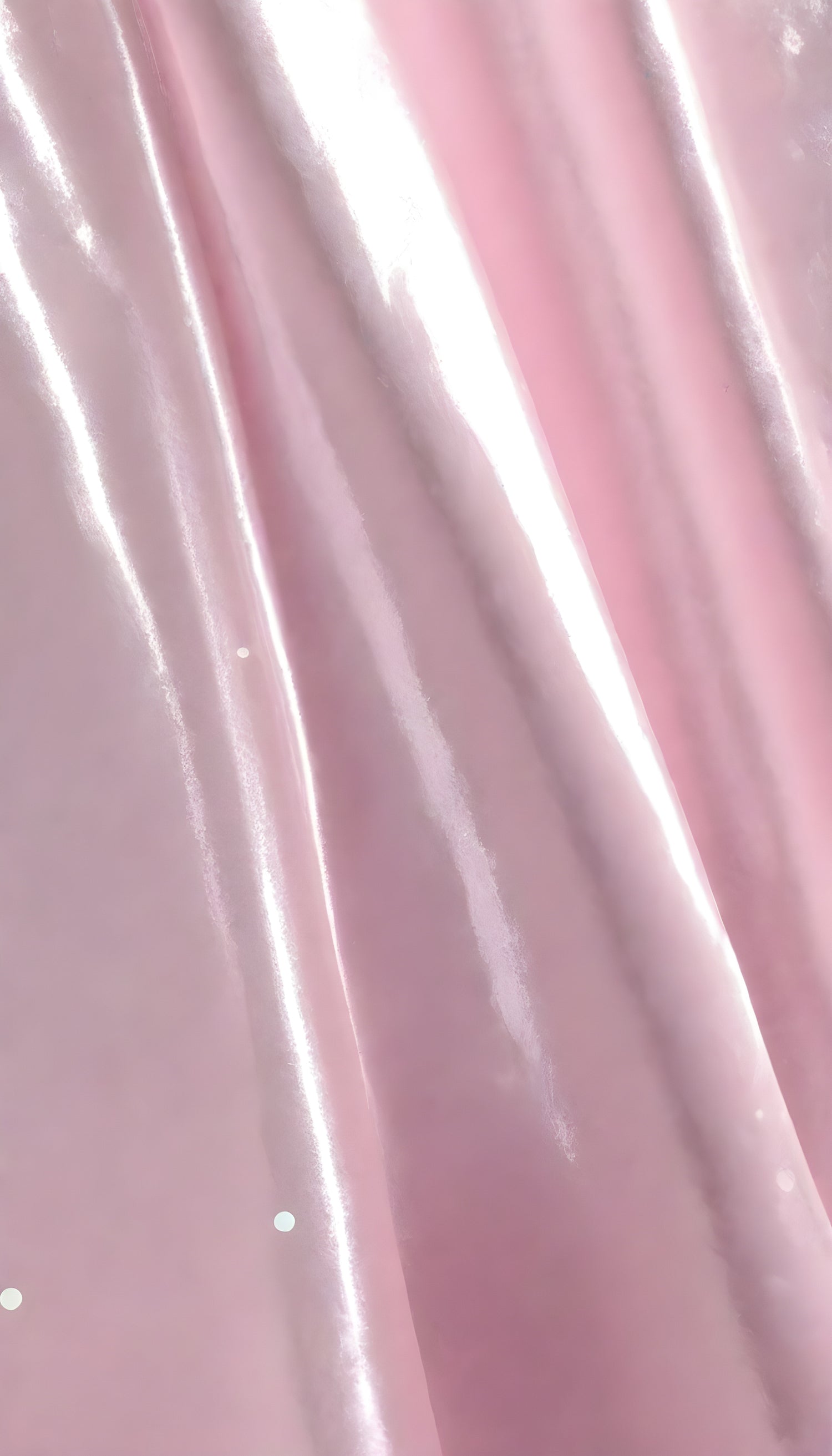 A close-up view of soft, shiny pink fabric draped elegantly, highlighting its smooth texture and sheen, perfect for luxurious designs