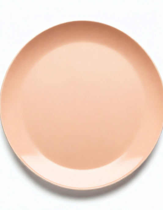 Simple round ceramic plate in soft peach color suitable for dining and decorative purposes at home