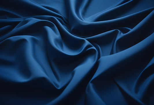 Dark blue satin fabric draped elegantly showcasing rich texture and sheen under soft lighting, perfect for fashion and design applications