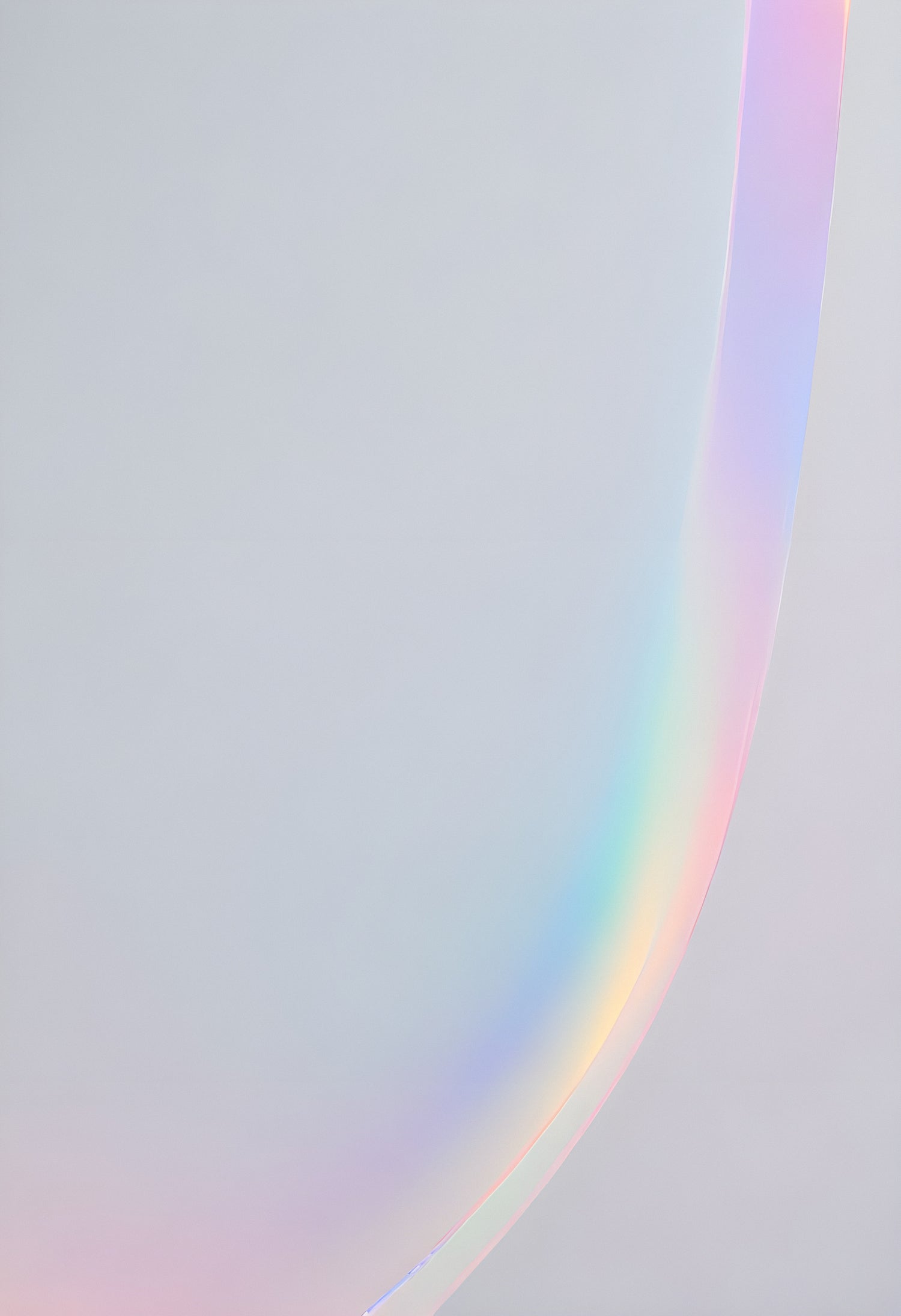 A soft pastel rainbow arching across a light gray background creates a serene and calming atmosphere during daylight