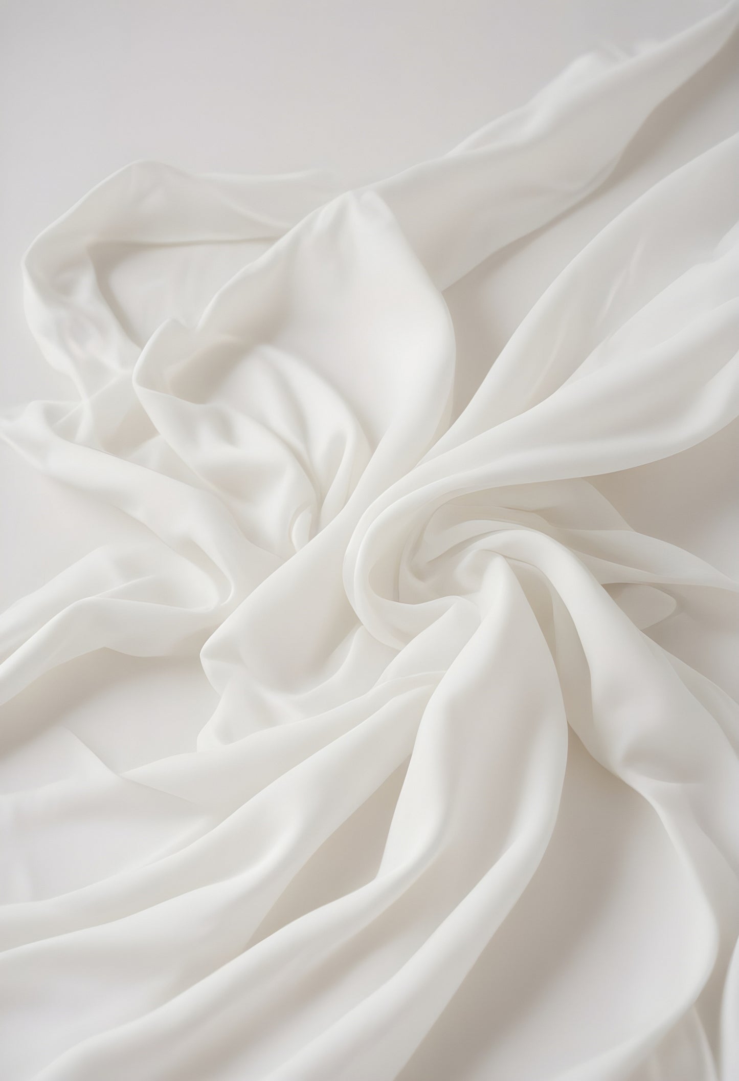 Delicate white fabric draped artistically on a light surface showcasing texture and softness