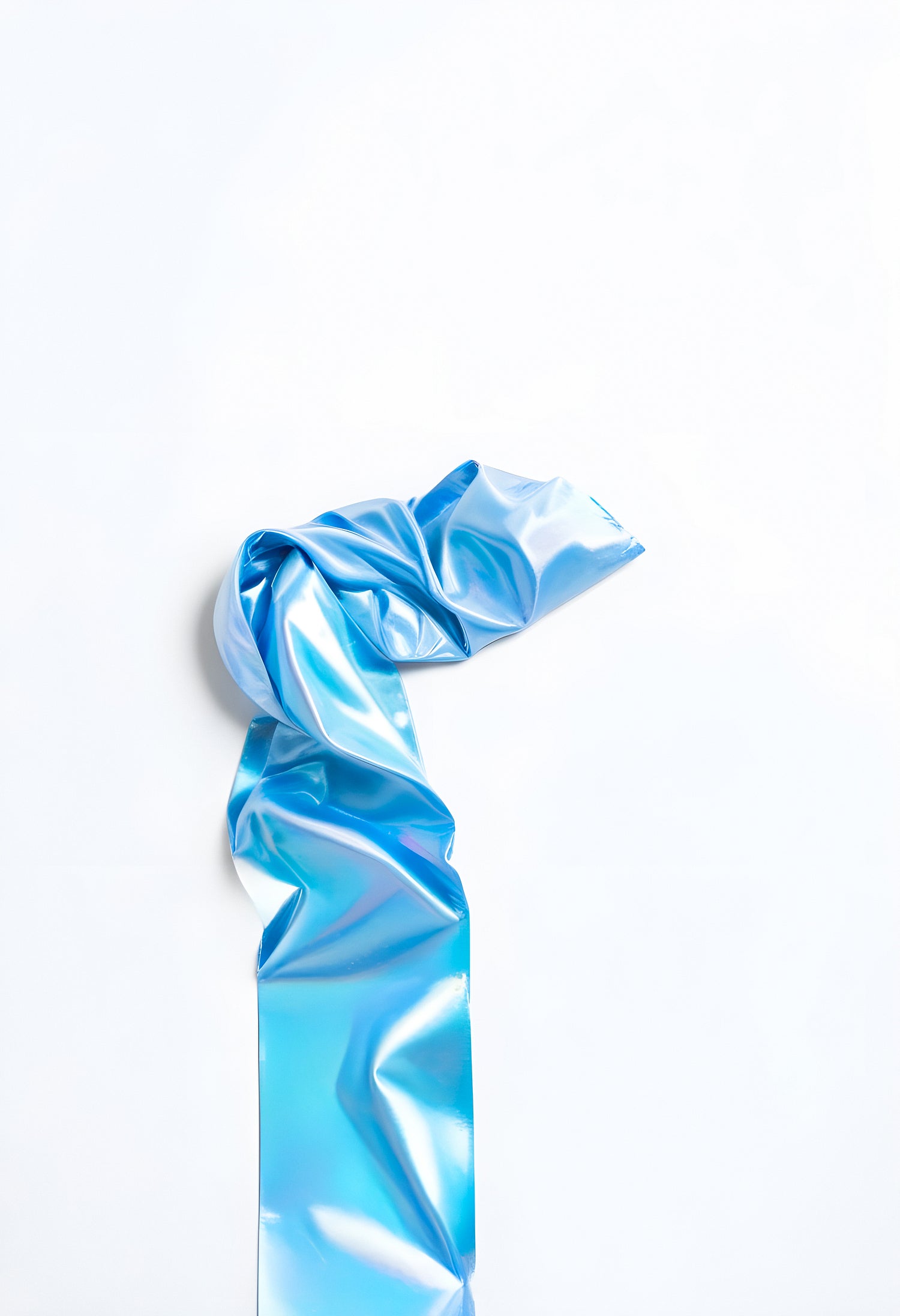 Shiny blue ribbon twisted elegantly against a white background during a creative arts project