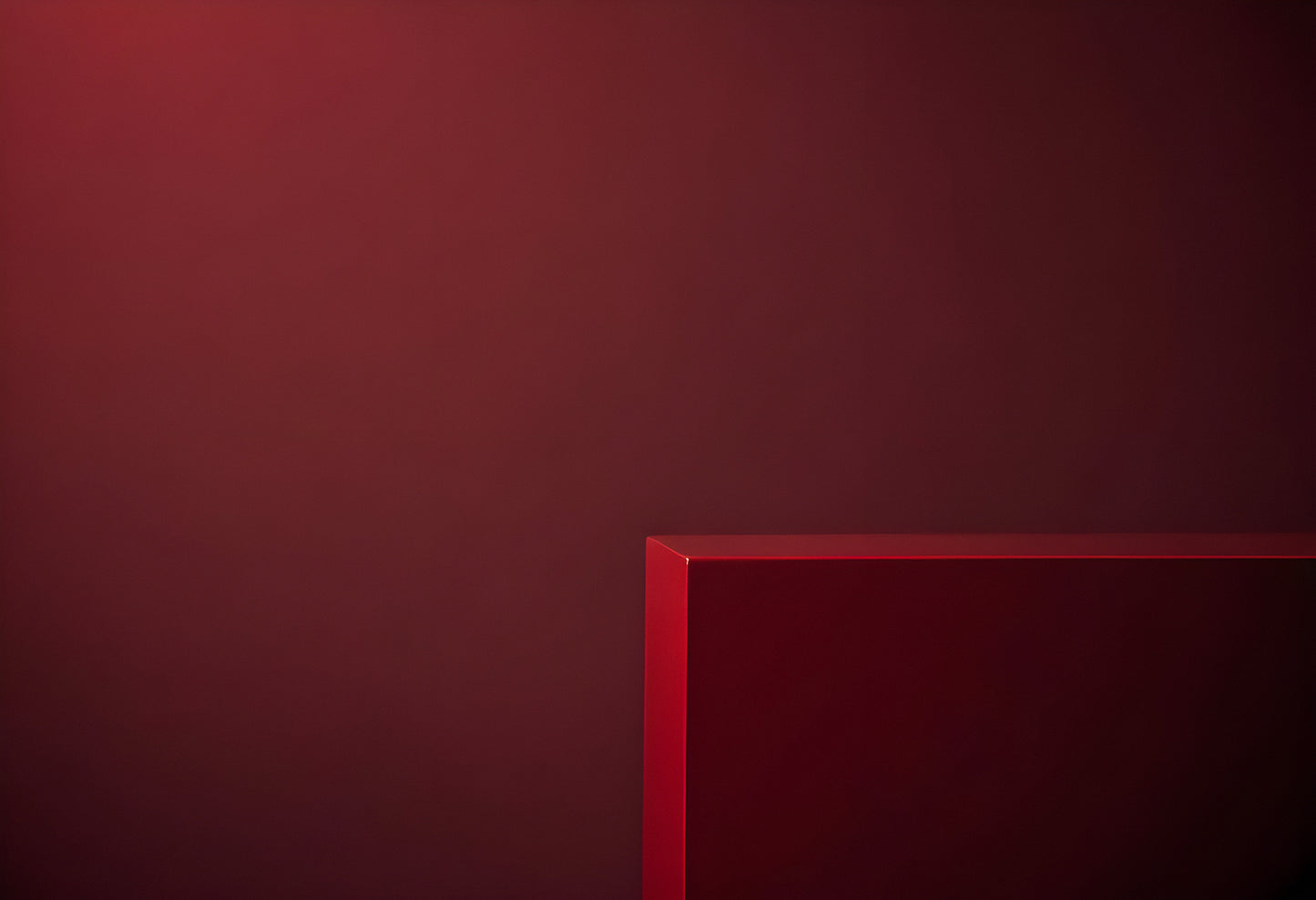 A deep red background with a textured surface and a red geometric shape creating a minimalistic and modern artistic composition