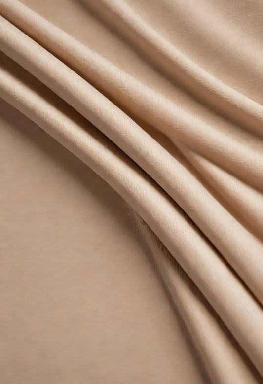 Soft, textured fabric draping elegantly against a neutral background in warm, muted tones