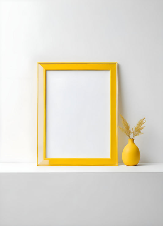 A bright yellow frame and minimalist vase with decorative grass placed on a white shelf in a modern interior setting