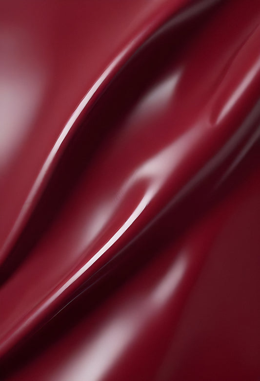 Deep maroon fabric draped elegantly on a surface, showcasing smooth texture and subtle shine in soft lighting