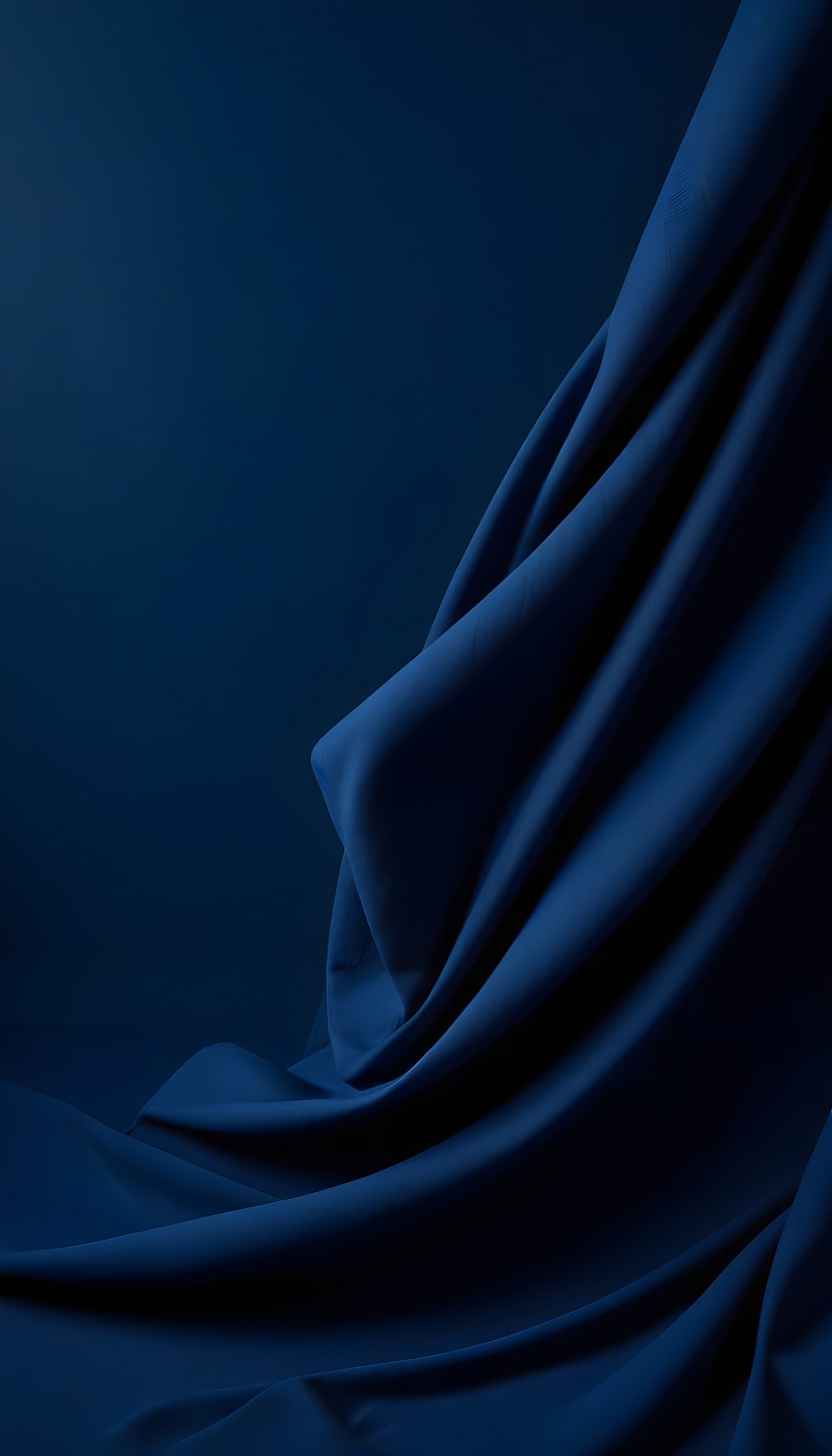 Soft blue fabric drapes gracefully, creating delicate folds and shadows in a serene atmosphere