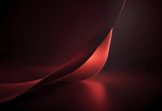 Flowing red fabric draped elegantly on a dark background, creating soft curves and shadows in low light