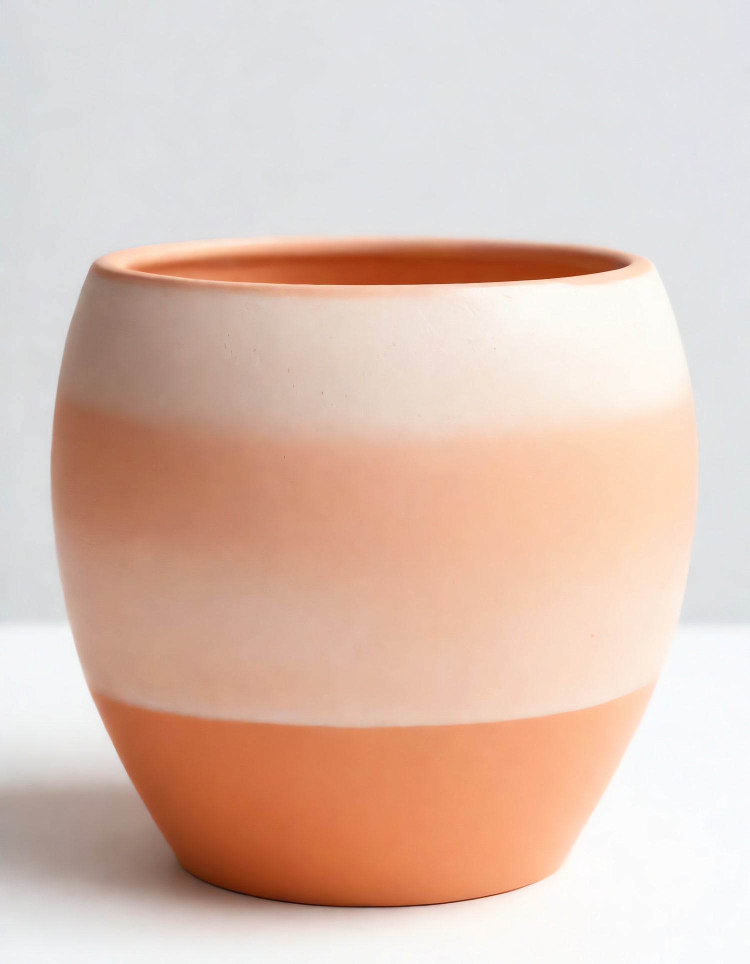 Simple ceramic planter with a smooth gradient from warm peach to soft cream, perfect for indoor or outdoor decor