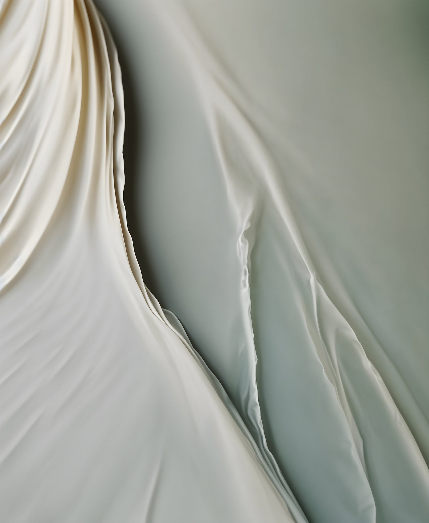 Soft fabric draped elegantly in a gentle flow with subtle textures