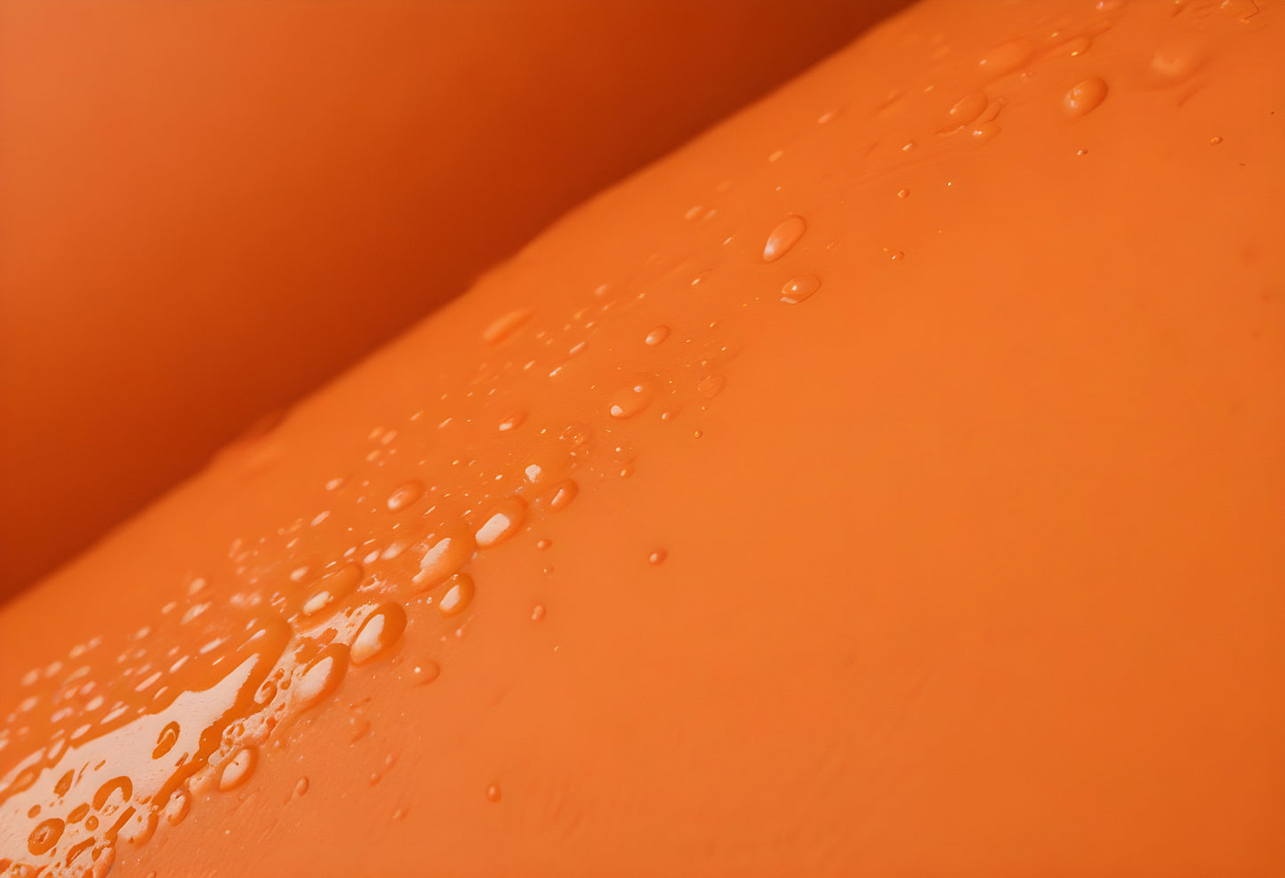 Water droplets on a vibrant orange surface captured in a close-up during daylight. Generative AI