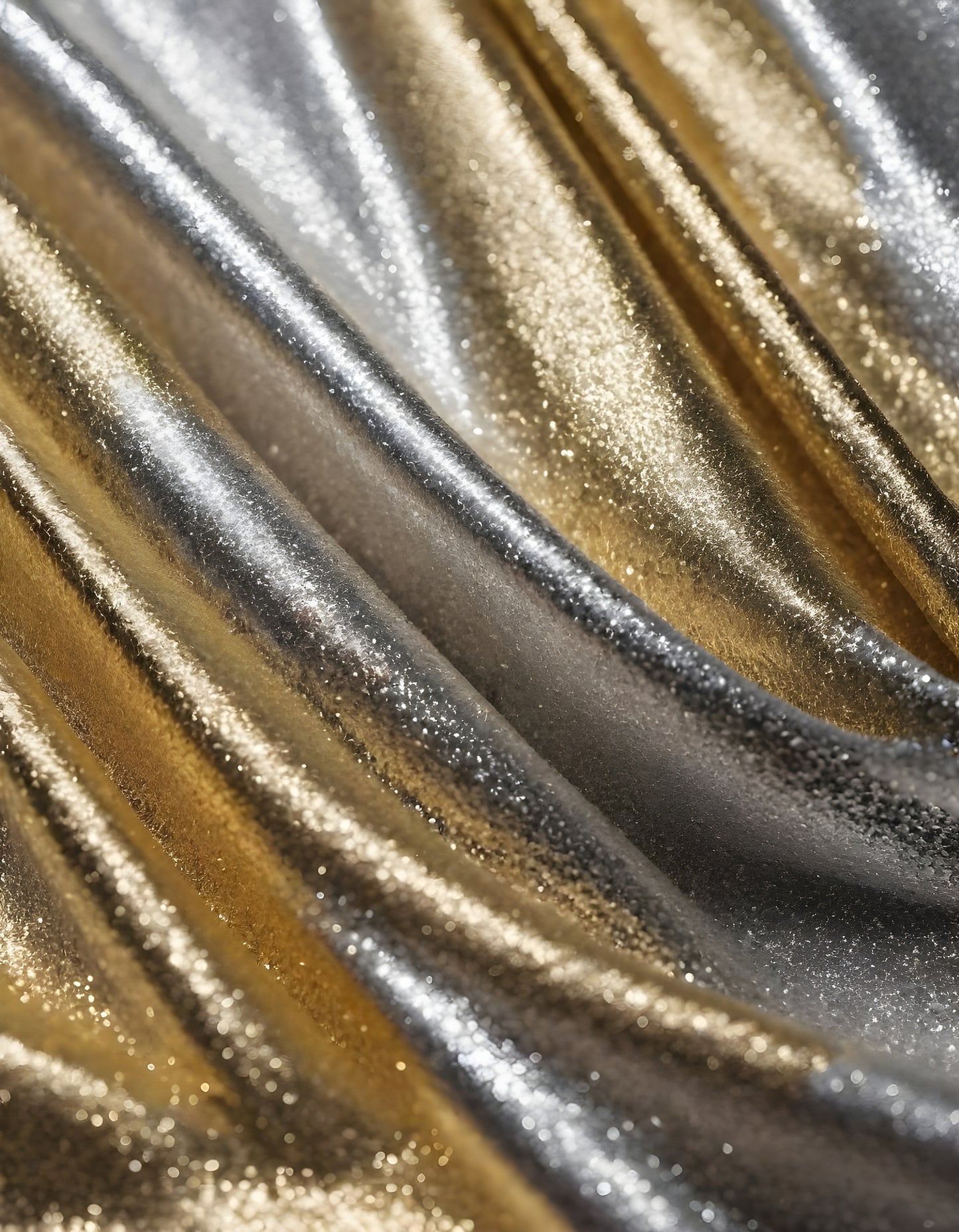 Metallic golden and silver fabric creates elegant textures with intricate folds and reflections under soft lighting