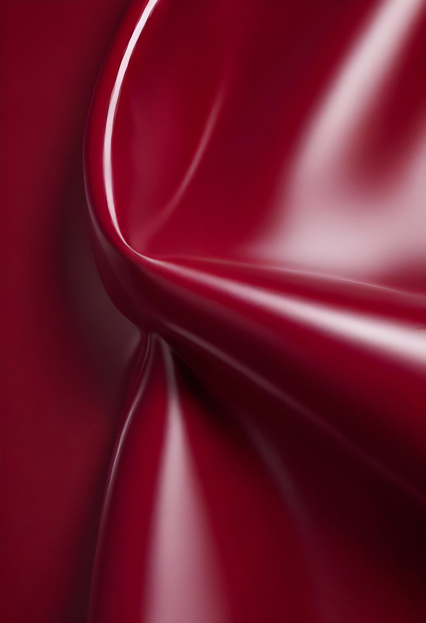 Deep maroon fabric draped elegantly on a surface, showcasing smooth texture and subtle shine in soft lighting