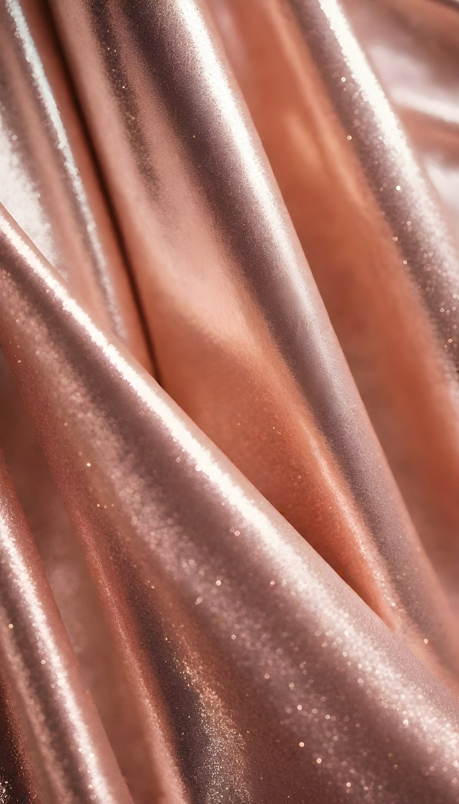 Shimmering rose gold fabric draping elegantly with soft folds under bright light in a studio setting