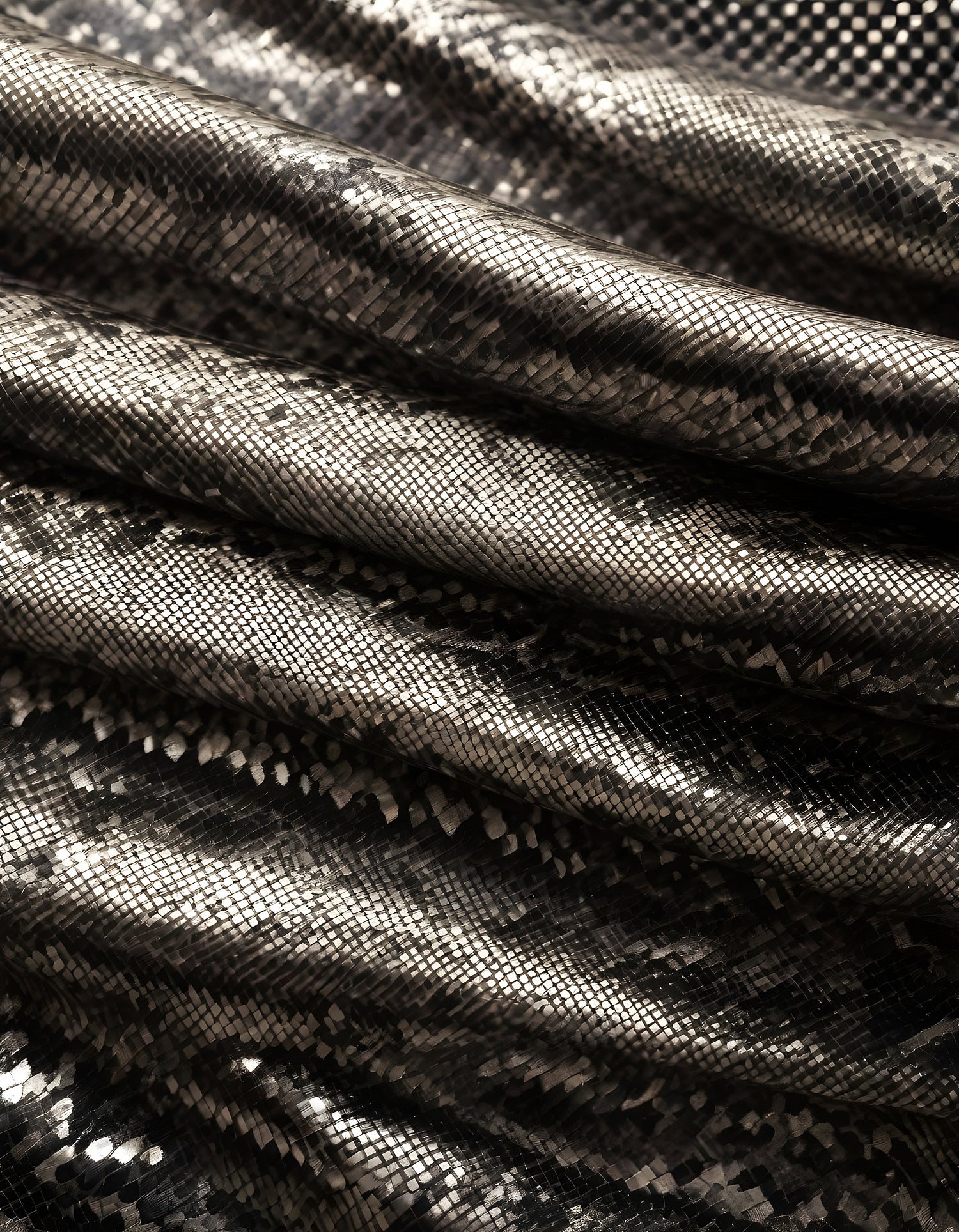 Elegant metallic fabric with a textured snake skin pattern draped softly