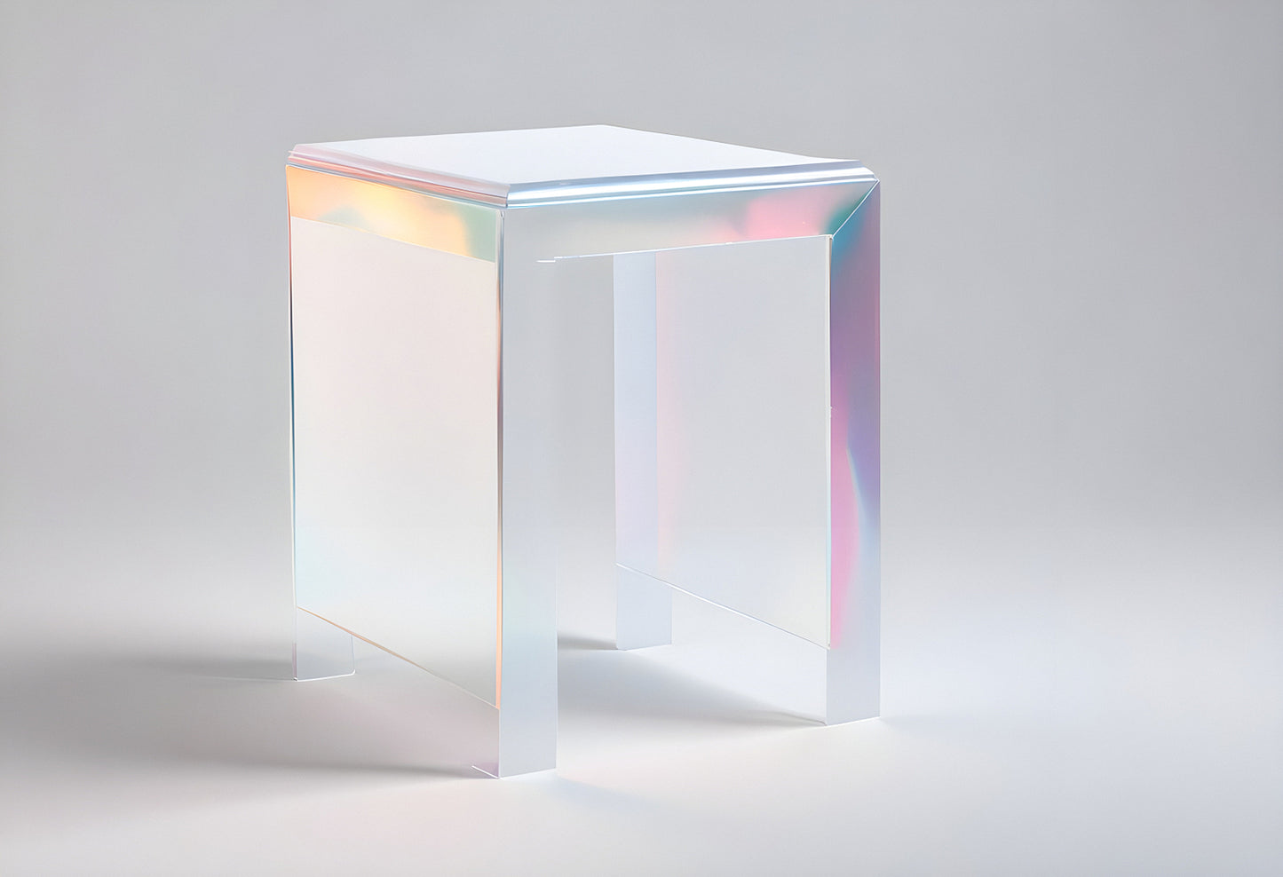 A clear acrylic side table with iridescent edges illuminated under soft lighting in a minimalist studio space