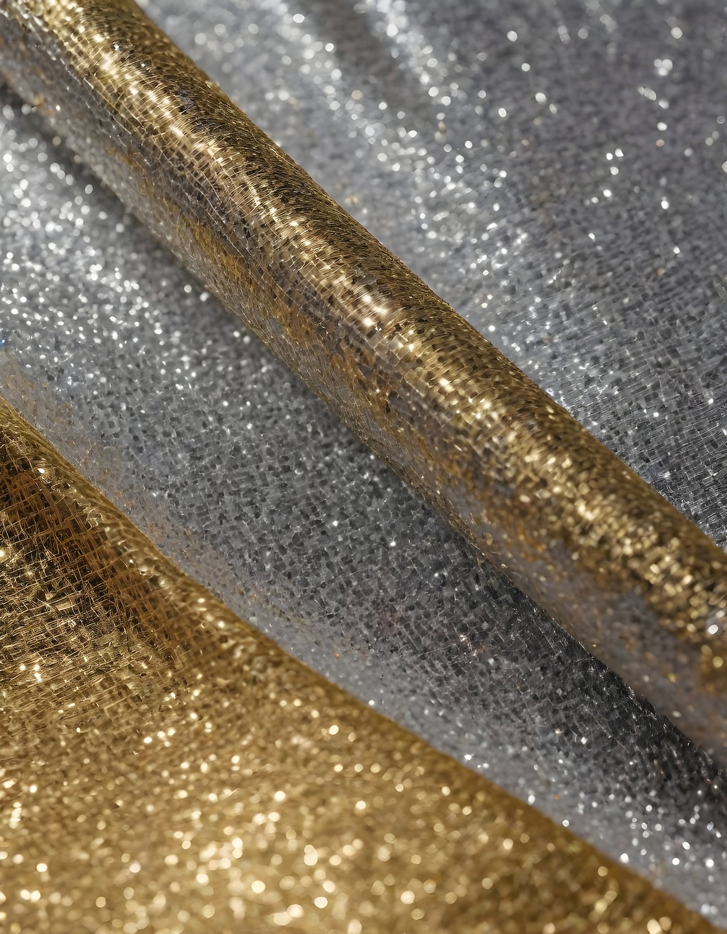 Metallic golden and silver fabric creates elegant textures with intricate folds and reflections under soft lighting