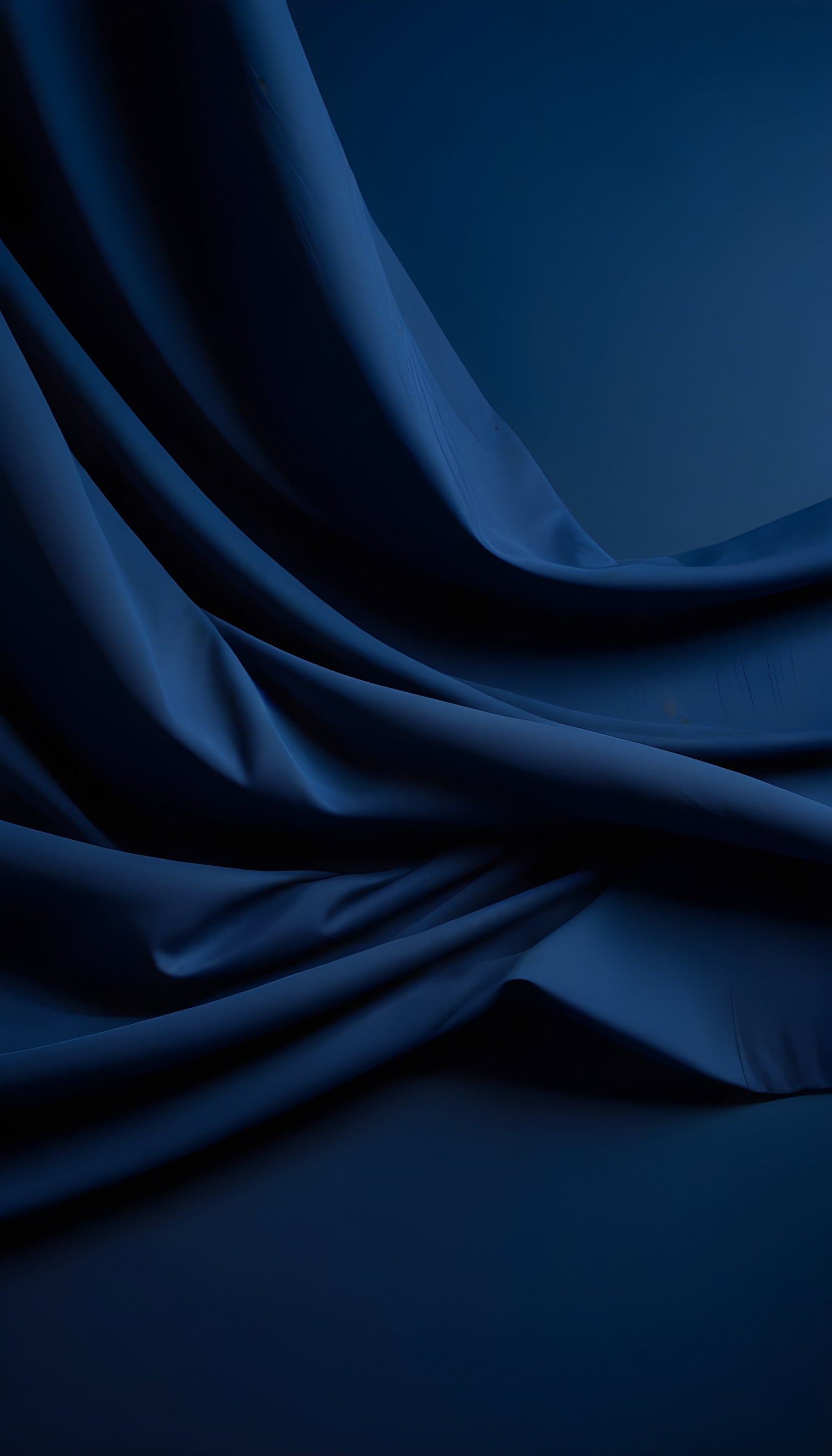 Elegant dark blue fabric draped gracefully across a surface showcasing rich textures and smooth folds in soft lighting