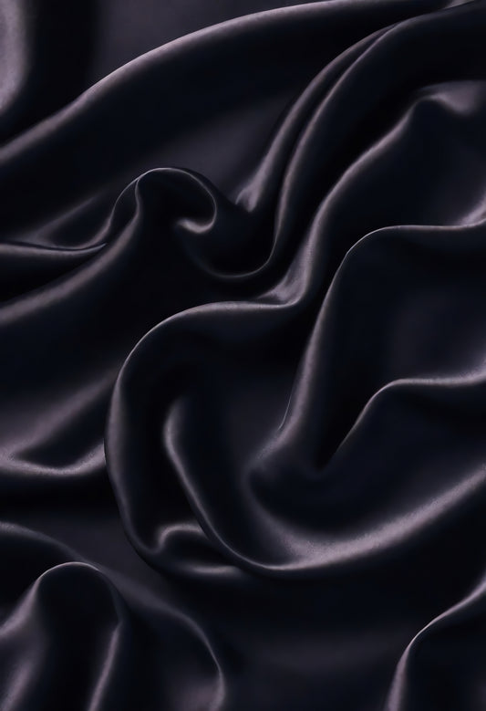 Luxurious dark satin fabric draped elegantly in soft folds creating a rich and inviting texture suitable for various design projects