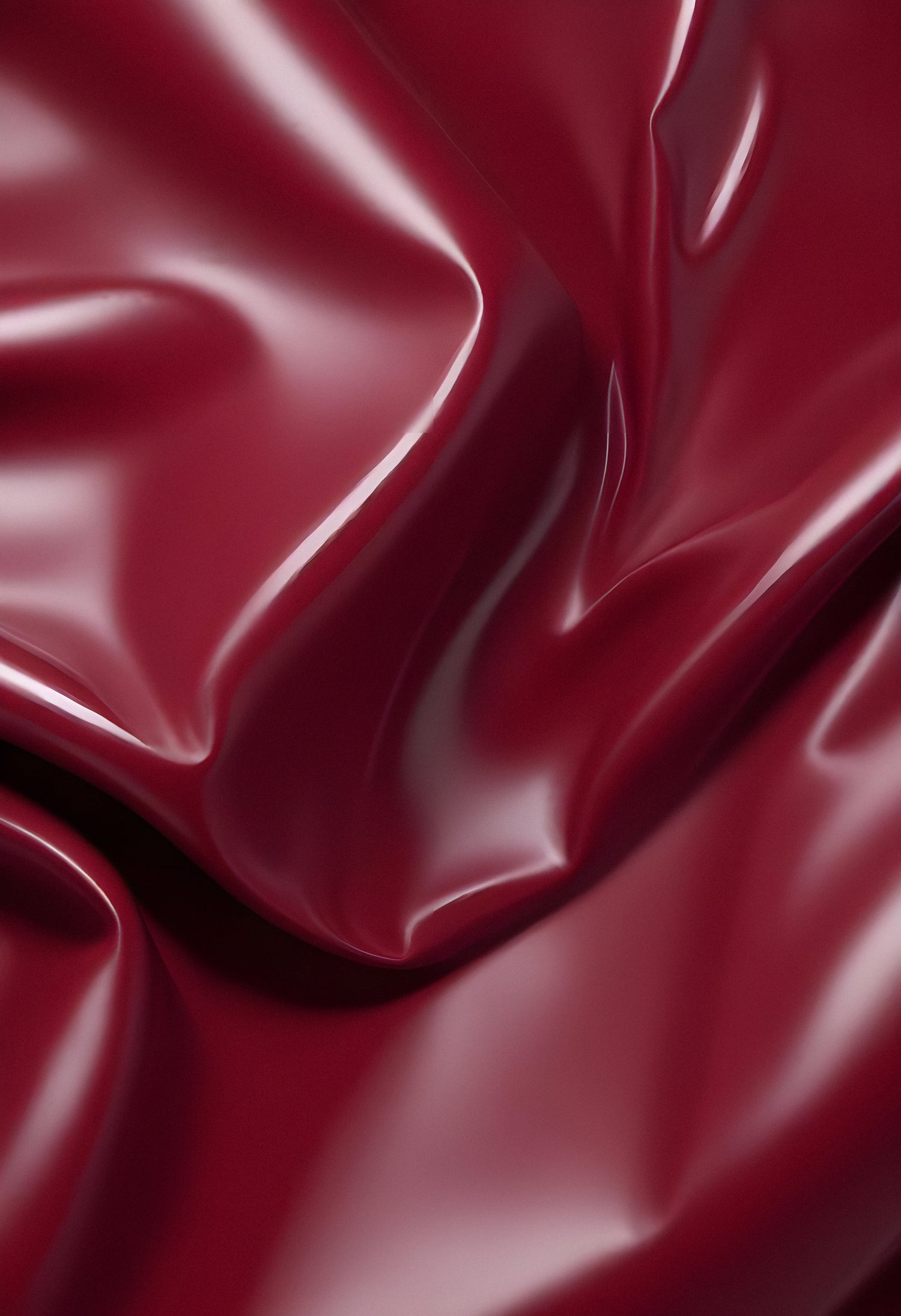 Deep maroon fabric draped elegantly on a surface, showcasing smooth texture and subtle shine in soft lighting