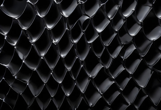 Textured black surface with geometric patterns illuminated in soft light