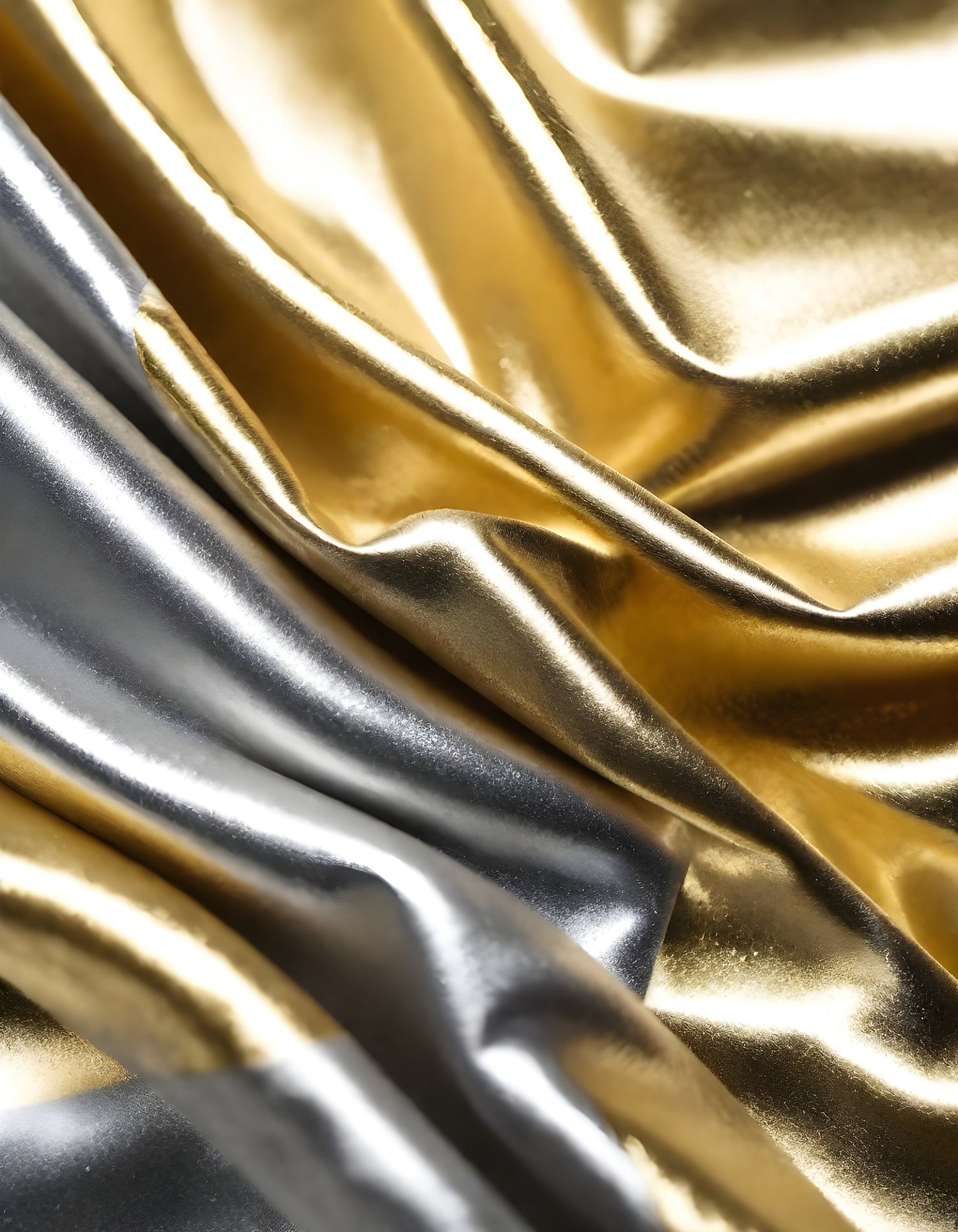 Metallic golden and silver fabric creates elegant textures with intricate folds and reflections under soft lighting