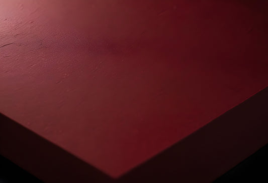 Close-up view of textured red surface highlighting light patterns in a dimly lit setting during evening hours